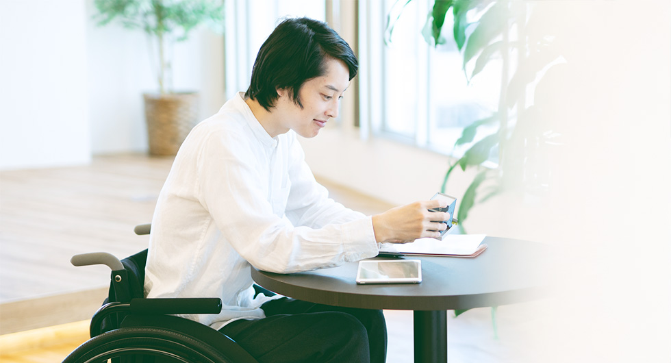 車椅子の男性がコワーキングスペースにいるようす